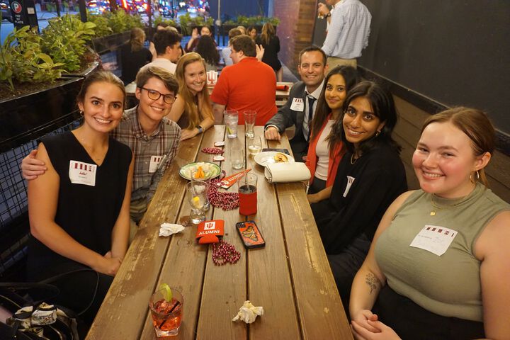 A group of IU alumni in Chicago sits around an outside table.